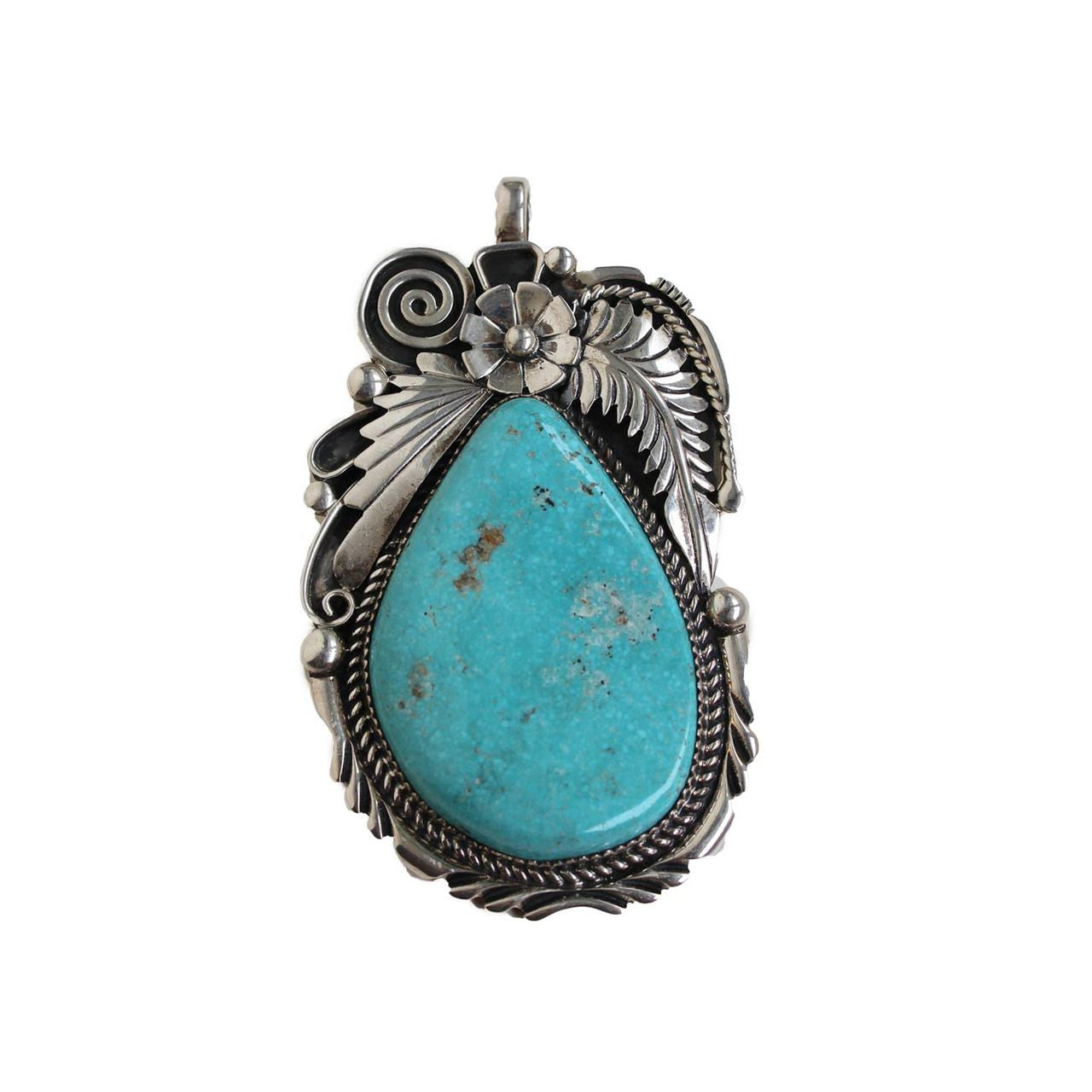 Beautiful handmade pendant in a tear drop shape. Hand picked turquoise in a silver floral setting.